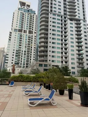 a row of blue chairs sitting on a patio with tall buildings at Marina Walk View Luxury 1BR close to JBR beach! in Dubai