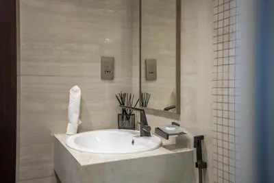 a bathroom with a sink and a mirror at Samaya Holiday Homes - Modern Luxe Apartments - Nobles Tower in Dubai