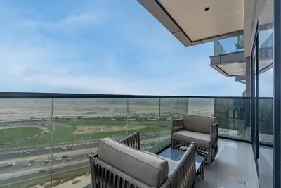 a balcony with chairs and a view of a highway at Samaya Holiday Homes - Modern Luxe Apartments - Nobles Tower in Dubai