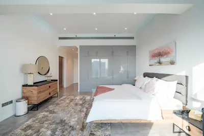 a bedroom with a bed and a dresser and a mirror at Private Marina 5 Master Bedrooms & Private Pool in Dubai