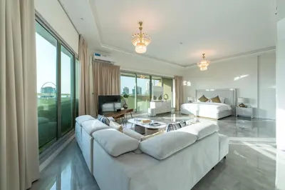 a living room with a large white couch and a bed at Private Marina 5 Master Bedrooms & Private Pool in Dubai