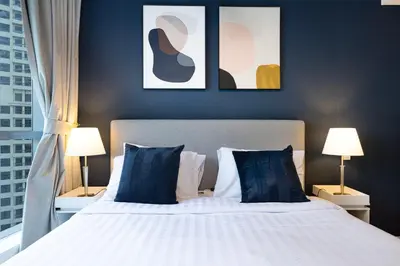 a bedroom with a large bed with blue pillows at Modern 1BR Apt With Access to Jacuzzi, Sauna & Pool in Dubai