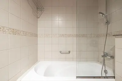 a white bathroom with a tub and a shower at Modern 1BR Apt With Access to Jacuzzi, Sauna & Pool in Dubai