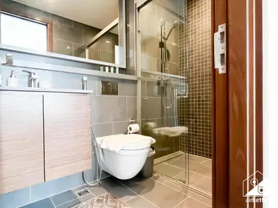 a bathroom with a toilet and a glass shower at Luxury 1-Bed in Meydan with Balcony & City Views in Dubai