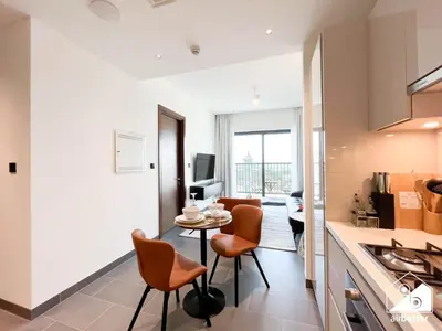 a kitchen and living room with orange chairs and a table at Luxury 1-Bed in Meydan with Balcony & City Views in Dubai