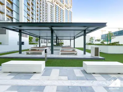 a pavilion with benches and tables in a building at Premium 1BR Retreat, Balcony Bliss, Pool & Gym in Dubai