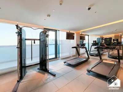 a gym with treadmills and ellipticals in a building at Premium 1BR Retreat, Balcony Bliss, Pool & Gym in Dubai
