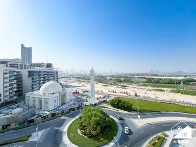 an aerial view of a city with a clock tower at Premium 1BR Retreat, Balcony Bliss, Pool & Gym in Dubai