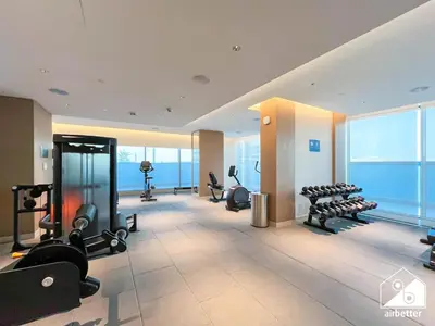a gym with treadmills and exercise equipment in a building at Premium 1BR Retreat, Balcony Bliss, Pool & Gym in Dubai