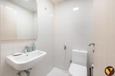 a white bathroom with a sink and a toilet at Vogue Jeewar JVC near Circle Mall, One Bedroom Apartment with Balcony and Park view, Access to all Amenities in Dubai