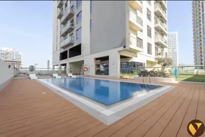 a swimming pool in the middle of a building at Vogue Jeewar JVC near Circle Mall, One Bedroom Apartment with Balcony and Park view, Access to all Amenities in Dubai