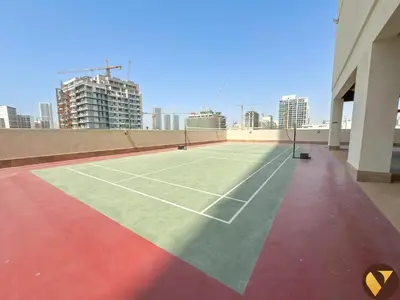 a tennis court on the roof of a building at Vogue Jeewar JVC near Circle Mall, One Bedroom Apartment with Balcony and Park view, Access to all Amenities in Dubai