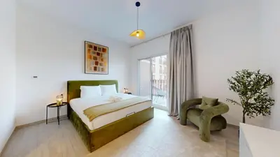 a bedroom with a bed and a chair and a window at Vacationer l Upgraded 1 Bedroom l near Circle Mall in Dubai