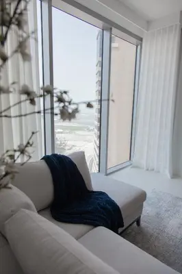 a living room with a couch and a large window at Royal suites LIv Marina views in Dubai