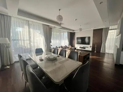 a living room with a dining table and a couch at Room for rent in a luxury villa in Dubai