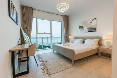 a bedroom with a bed and a desk and a window at Magical La Vie JBR Apt with Private Beach Access in Dubai