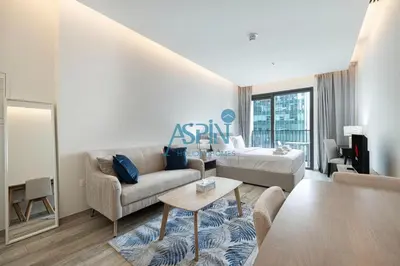 a living room with a couch and a bed at Aspin Modern Studio Apartment in AHAD Residency in Dubai