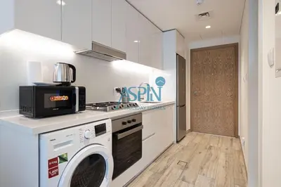a kitchen with a washer and dryer in a room at Aspin Modern Studio Apartment in AHAD Residency in Dubai