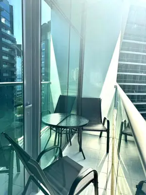 a balcony with two tables and chairs on a building at Seven Palm Studio - Direct Beach Access- Rooftop Infinity Pool in Dubai