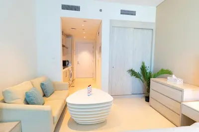 a living room with a couch and a table at Seven Palm Studio - Direct Beach Access- Rooftop Infinity Pool in Dubai