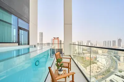 a swimming pool with two chairs on a balcony with a view at Modern 2BR Retreat in JVC with Private Pool Balcony in Dubai