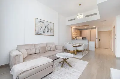 a living room with a couch and a table at Modern Aura Living Chic 1BR Hideaway in JVC in Dubai