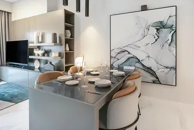 a dining table and chairs in a living room at FAM Living - Urban Stays - MAG318, 5 mins to Burj Khalifa in Dubai