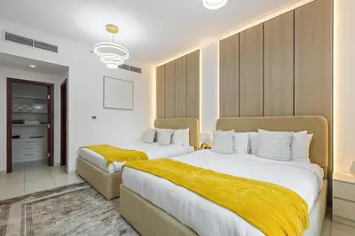 two beds in a hotel room with yellow blankets at Serene 2BR Burj Khalifa & Fountain View in Dubai