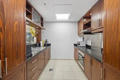 a large kitchen with wooden cabinets and stainless steel appliances at Serene 2BR Burj Khalifa & Fountain View in Dubai