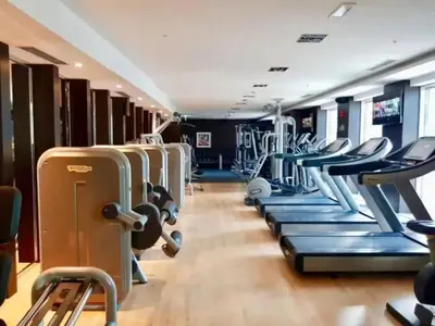 a gym with rows of treadmills and machines at Serene 2BR Burj Khalifa & Fountain View in Dubai