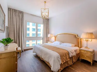 a bedroom with a large bed and a large window at Luxury in Dubai Marina 1BR beside Vida Yacht Club in Dubai