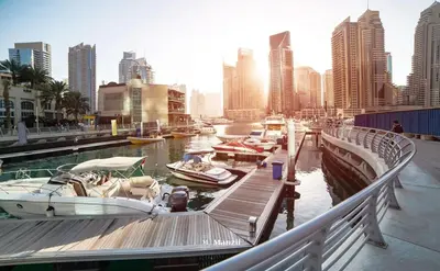 a group of boats docked at a dock in a city at Cozy 1BR Apartment in Dubai Marina with City Views in Dubai