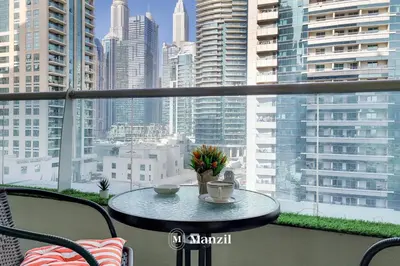 a table on a balcony with a view of a city at Cozy 1BR Apartment in Dubai Marina with City Views in Dubai