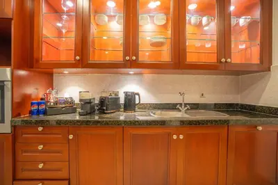 a kitchen with wooden cabinets and a sink at Zaafaran 5 Full Burj View Downtown Luxury Stay in Dubai