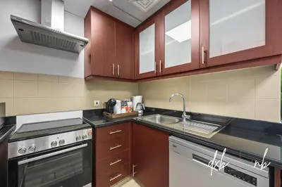 a kitchen with a sink and a stove top oven at Pistachio Pecan - Sea View - Luxury 1 BR Apartment at JBR Beach in Dubai
