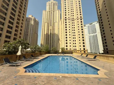 a swimming pool in a city with tall buildings at Pistachio Pecan - Sea View - Luxury 1 BR Apartment at JBR Beach in Dubai