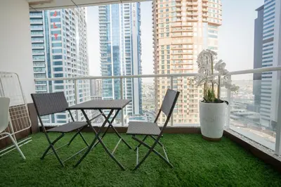 a table and chairs on a balcony with a view of a city at JLT Laguna Tower Spacious Studio with Lake View for 4 Guests in Dubai