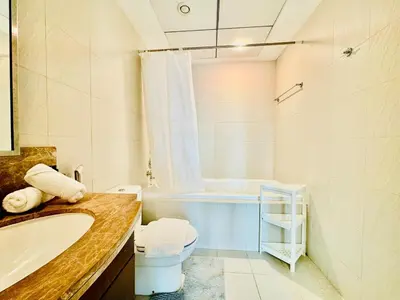 a bathroom with a tub and a toilet and a sink at Modern Apartment standpoint near dubai opera in Dubai