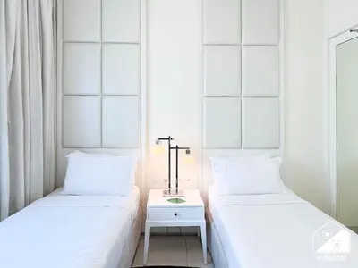 two beds sitting next to each other in a room at Elegant 2-Bed Retreat, Stunning Downtown Views in Dubai