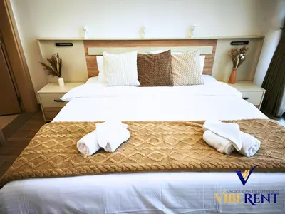 a bedroom with two beds with white sheets and towels at Modern 6 sleeper JVC Rooftop pool, tennis court 10 min to Marina in Dubai