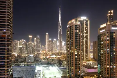 a view of a city at night with tall buildings at Luxury 1BR at Sterling East , Burj Khalifa Views in Dubai