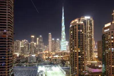 a view of a city skyline at night at Luxury 1BR at Sterling East , Burj Khalifa Views in Dubai