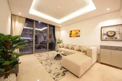 a living room with a couch and a table at Luxury 1BR at Sterling East , Burj Khalifa Views in Dubai
