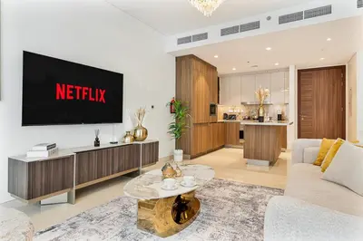 a living room with a tv on a wall at Deluxe, Elegant - 3BR - DT - Burj Khalifa View in Dubai