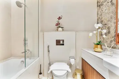 a bathroom with a toilet and a tub and a sink at Deluxe, Elegant - 3BR - DT - Burj Khalifa View in Dubai