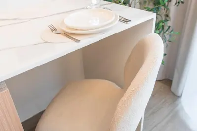 a chair at a table with a plate on it at New Studio Aura JVC Pool Gym Sauna Padel court in Dubai
