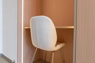 a white chair is sitting in a closet at New Studio Aura JVC Pool Gym Sauna Padel court in Dubai