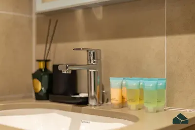 a bathroom sink with a faucet and four cups at Cozy 1BR for 3 with Community View by BMS in Dubai