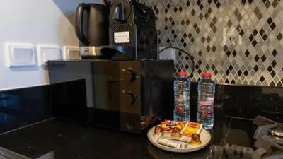 a counter with a coffee maker and bottles of water at Charming Studio with Cozy Vibes in Dubai