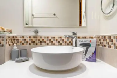 a bathroom with a large white sink and a mirror at Luxury Apartment in the Heart of the City in Dubai